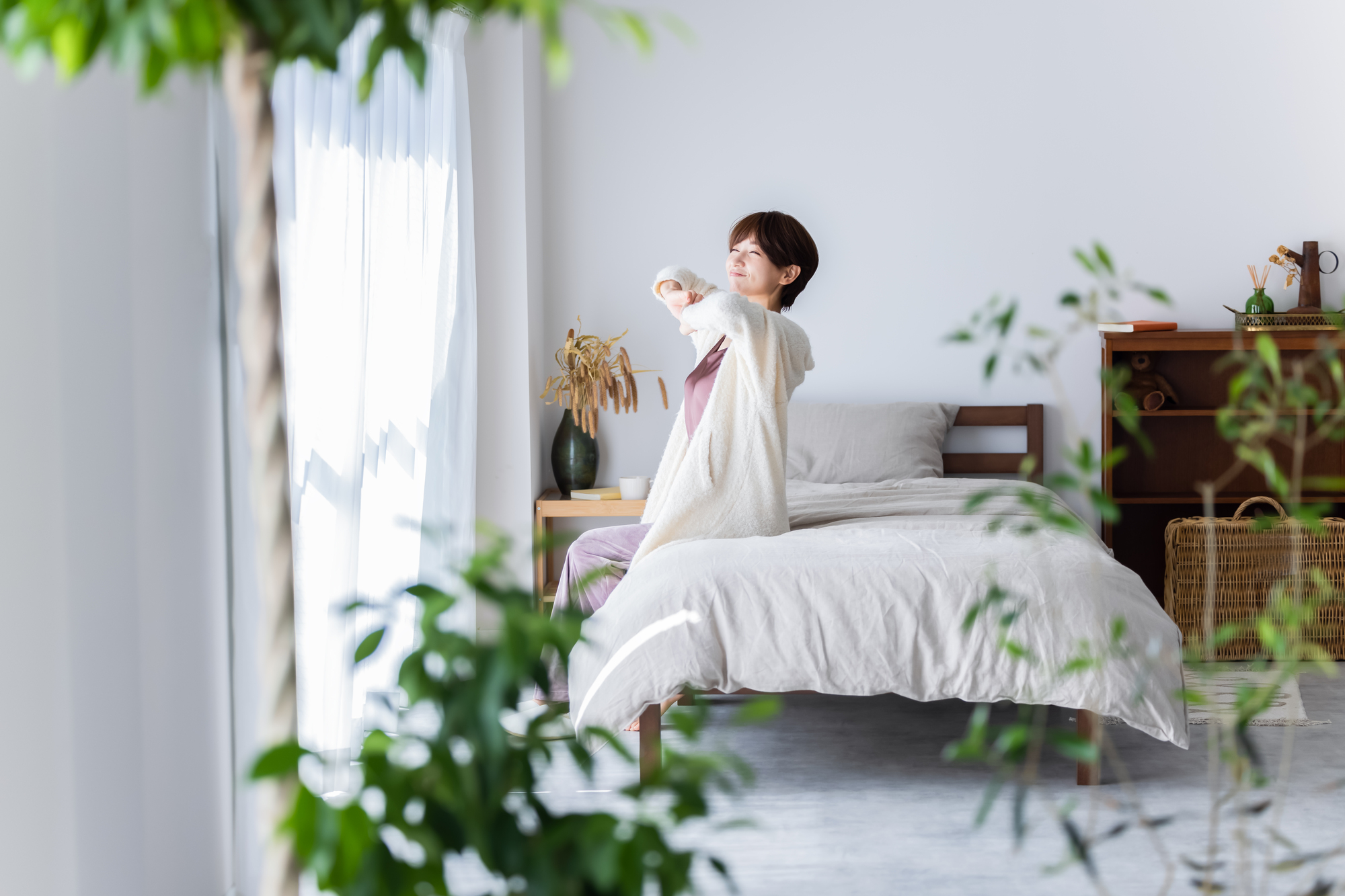 朝の明るい部屋でゆっくり身体を伸ばす女性